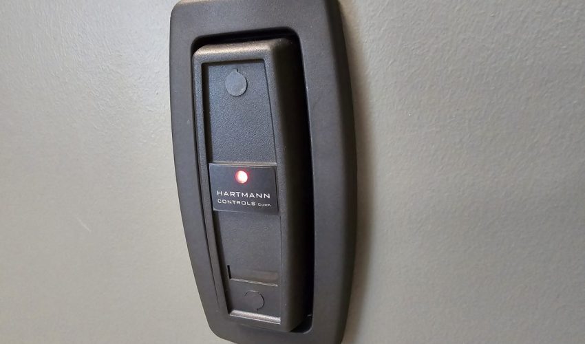 Access control card reader mounted on a wall beside a door