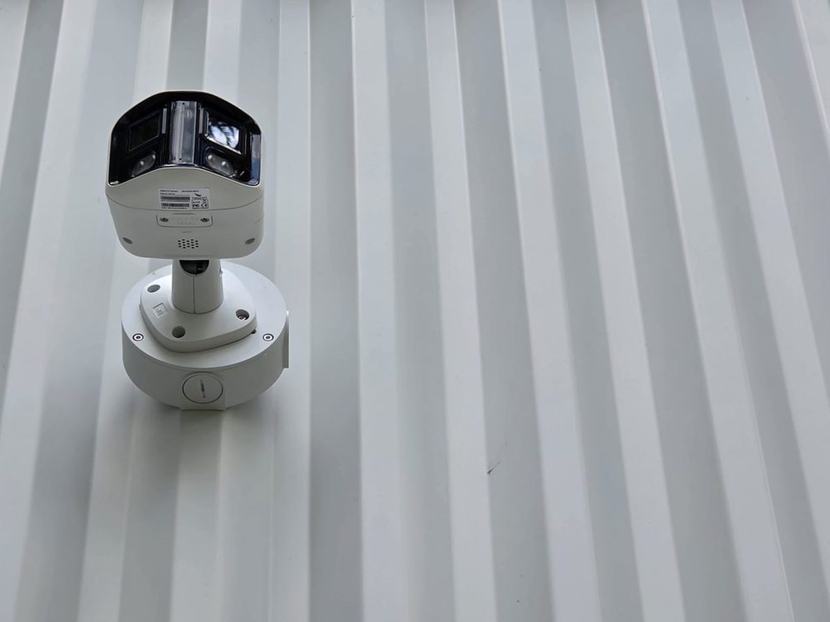 Dual-lens security camera mounted on exterior metal siding