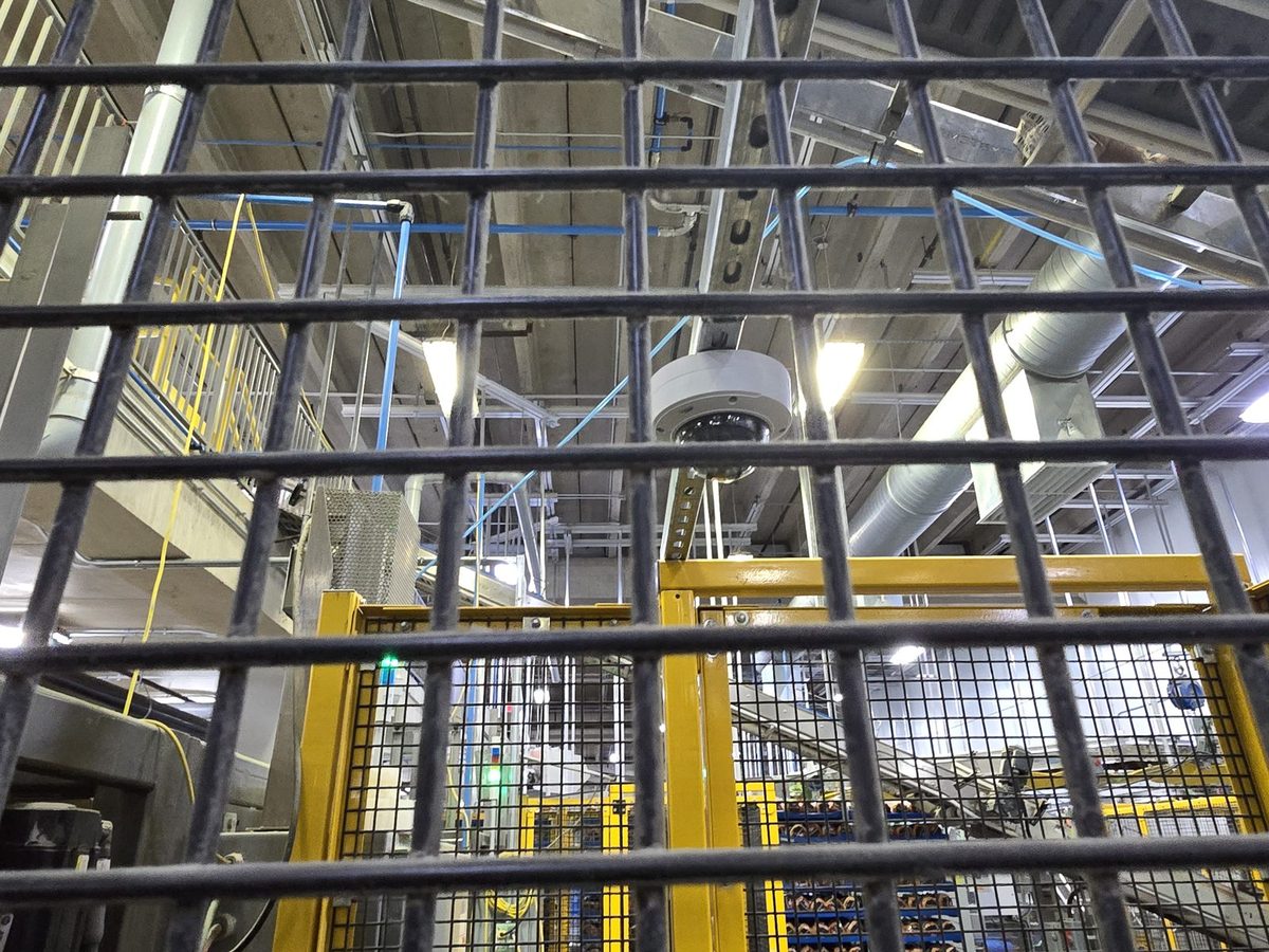 Dome security camera inside a secured cage in an industrial plant