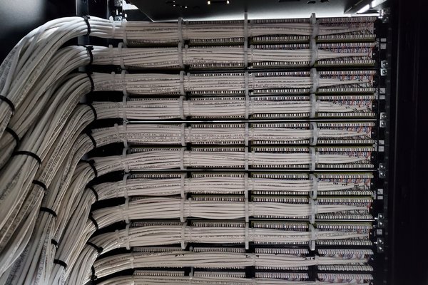 Server room rack with labelled cable bundles dressed into panels