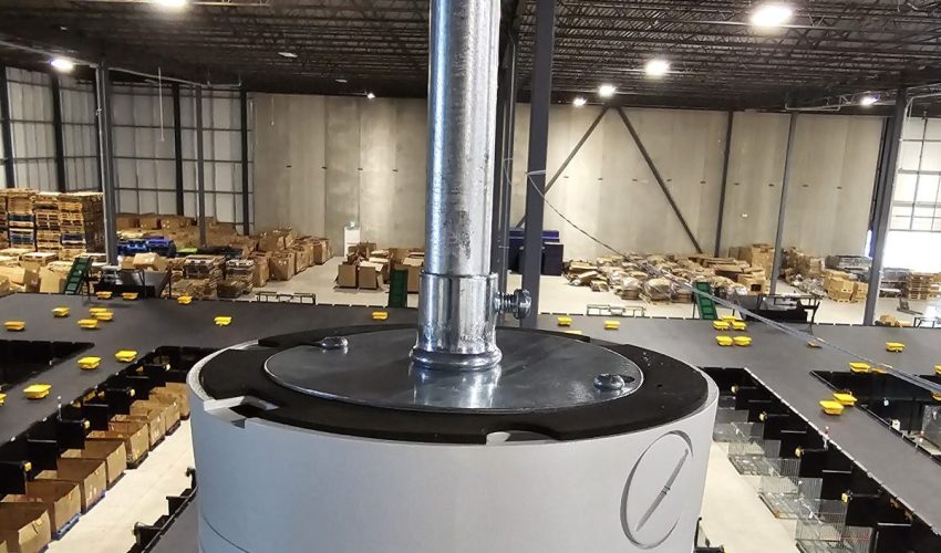 Security camera on a pendant mount above a warehouse sorting floor