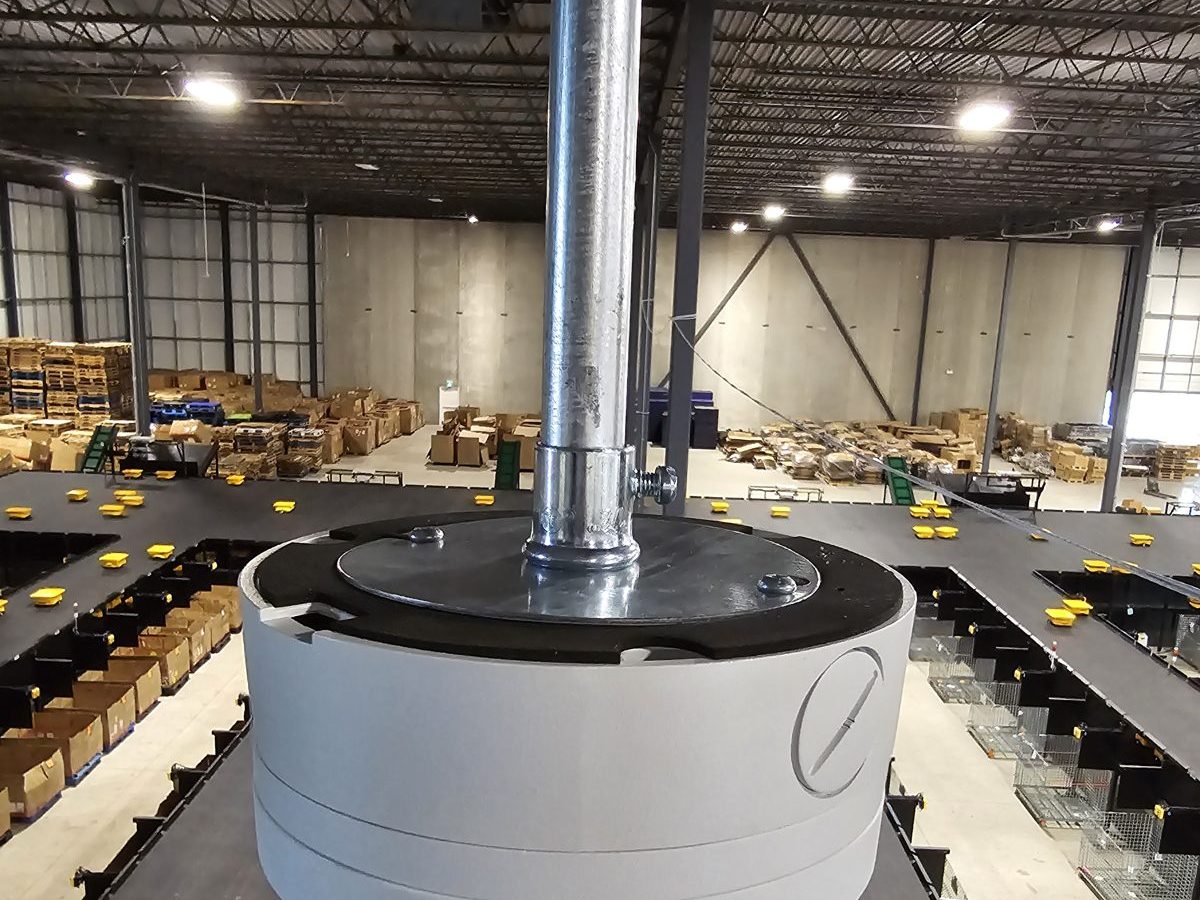 Security camera on a pendant mount above a warehouse sorting floor